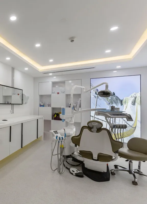 A modern dental clinic featuring a high-tech dental chair with attached equipment, a clean and bright interior.